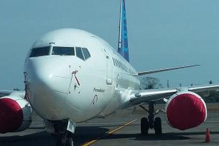 Bagian mesin Pesawat Garuda Indonesia ditutupi lain merah