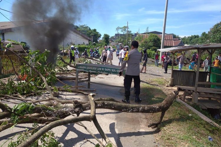 Aparat kepolisian di Kabupaten Gowa, Sulawesi Selatan, tengah melakukan pengamanan saat warga memblokade akses jalan ke pemakaman pasien covid-19. Kamis, (2/4/2020).