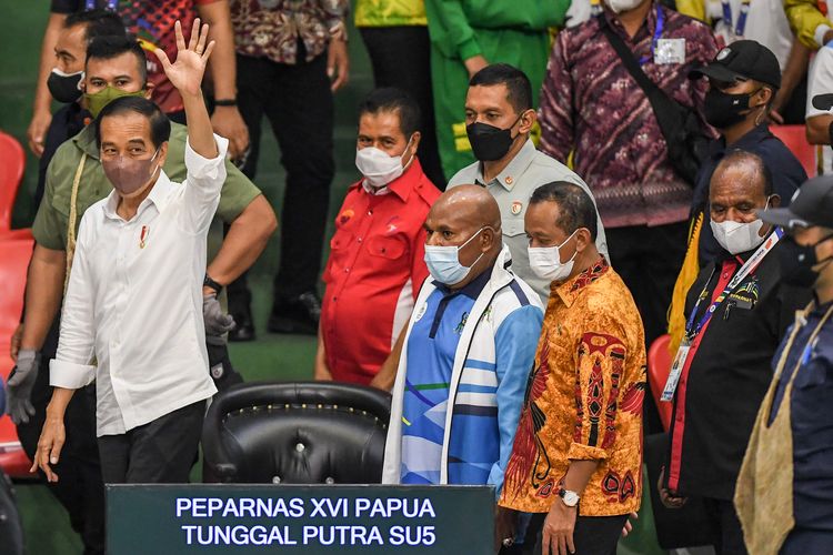 Presiden Joko Widodo (kiri) menyapa atlet Peparnas dan penonton saat berkunjung di Gor Cendrawasih, Jayapura, Papua, Sabtu (13/11/2021). Presiden Joko Widodo berkesempatan untuk mengunjungi venue judo dan bulu tangkis sebelum akhirnya menutup Peparnas Papua di Stadion Mandala. ANTARA FOTO/Raisan Al Farisi/nym.