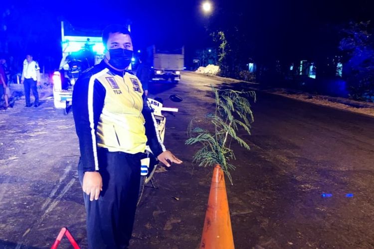 Petugas Satlantas Polres Tuban sedang melakukan olah tempat kejadian kecelakaan yang menyebebkan pengendara sepeda motor tewas usai menabrak truk parkir yang sedang mengalami kerusakan mesin. Senin (19/9/2022).