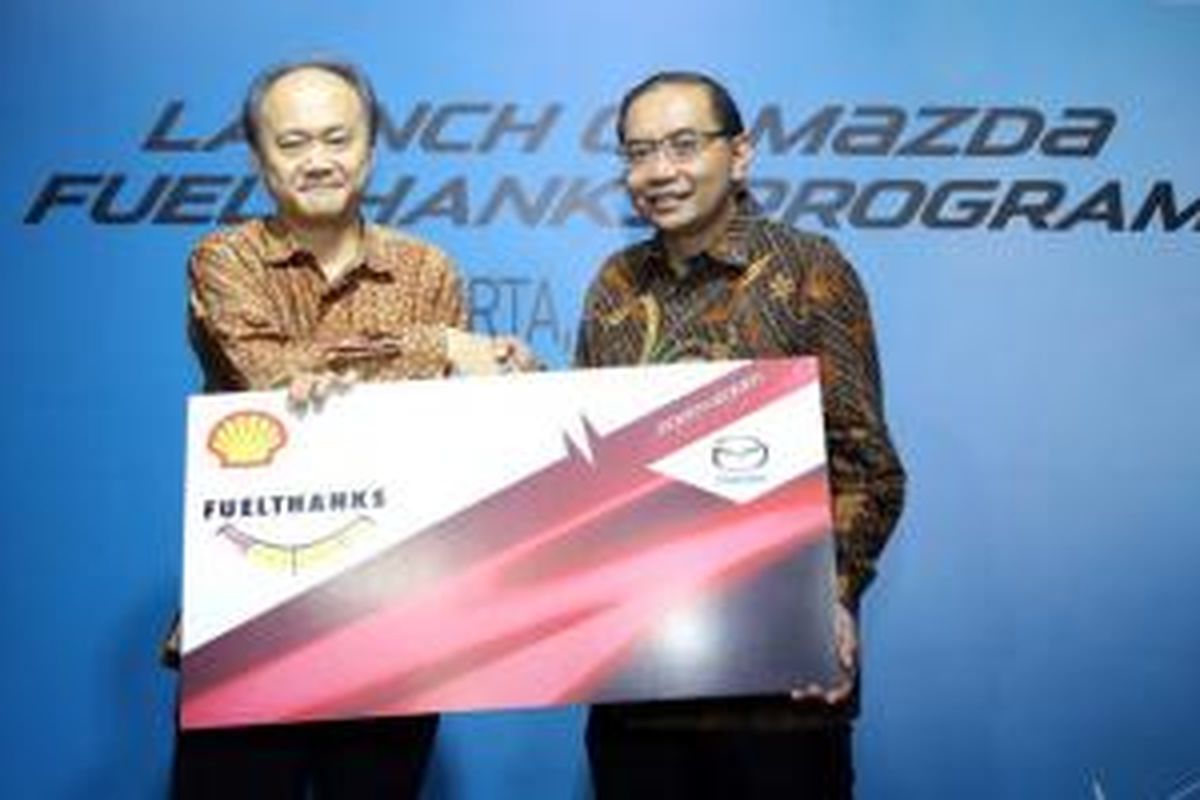 Keizo Okue, President Director Mazda Motor Indonesia (kiri) dan Wahyu Indrawanto, General Manager Retail for Shell Indonesia, Singapore, and Hongkong, memegang simbol Mazda Fuelthanks sebagai tanda peluncuran di Jakarta, Selasa (7/7/2015). 