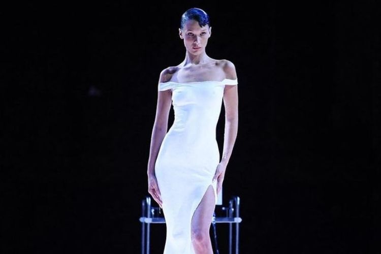 Bella Hadid tampil memukau dengan gaun putih yang disemprotkan ke tubuhnya saat menutup peragaan busana Coperni di Paris Fashion Week 2022.