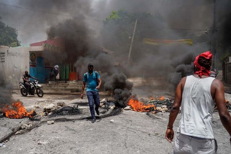 Warga Haiti yang memprotes harga tinggi dan kelangkaan membakar ban di jalan Port-au-Prince pada 13 Juli 2022.