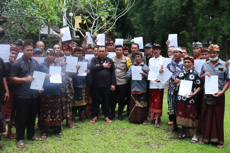 Bupati Jembrana I Nengah Tamba berfoto bersama 32 ketua kelompok Lembaga Pengelola Hutan Desa (LPHD) Jembrana sambil menunjukan komitmen tertulis untuk menjaga hutan Jembrana di Rumah Jabatan Bupati Jembrana, Jumat ( 21/10/2022).