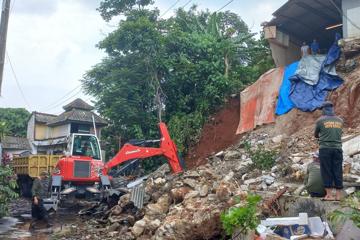 Petugas SDA Dinas PUPR Depok sedang menangani longsoran di perbatasan antara Perumahan Tirta Mandala dengan permukiman lain, Sukamaju, Depok pada Kamis (8/12/2022).