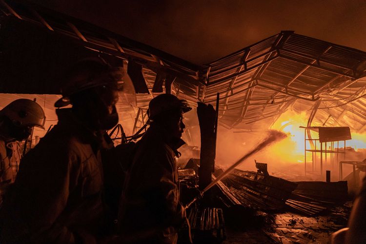 Petugas pemadam kebakaran berupaya memadamkan api yang membakar kompleks Relokasi Pasar Johar di Semarang, Jawa Tengah, Rabu (2/2/2022). Belum diketahui penyebab serta kerugian akibat terbakarnya area Blok F dan Blok E di kompleks relokasi pasar tradisional tersebut. Hingga Rabu pukul 21.15 WIB, belasan mobil pemadam kebakaran dibantu mobil meriam air kepolisian beserta personel TNI-Polri dan BPBD Kota Semarang masih berupaya memadamkan kobaran api.