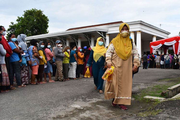 Residents carry cooking oil purchased during the operation of the cooking oil market at the Bakorwil Madiun pendapa yard, East Java, Tuesday (15/2/2022).  The operation of the Cheap Cooking Oil Market with the Governor of East Java Khofifah Indar Parawansa provides around three thousand liters of packaged cooking oil which is sold at a price of Rp 12,500 per liter and each ID card holder gets two liters.