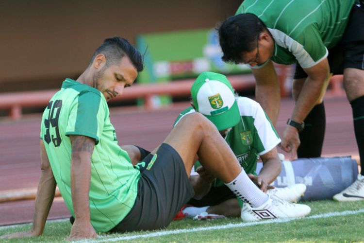 Gelandang Persebaya, Raphael Maitimo, saat menjalani perawatan oleh fisioterapis pada sesi latihan tim di Stadion Jenggolo, Sidoarjo, Kamis (2/8/2018).
