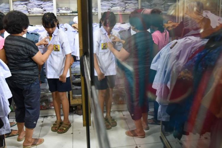 Foto ilustrasi. Seorang siswa mencoba seragam sekolah yang dijual di Pasar Pringgan, Medan, Sumatera Utara, Jumat (14/7).