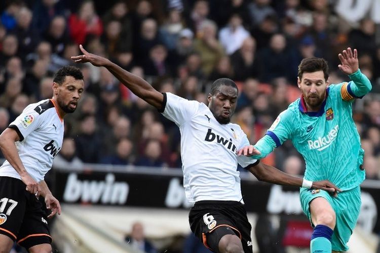 Pemain tengah Republik Afrika Tengah-Prancis, Geoffrey Kondogbia (kiri) menantang pemain depan Argentina Lionel Messi (tengah) Barcelona selama pertandingan sepak bola Liga Spanyol, Valencia CF melawan FC Barcelona di stadion Mestalla di Valencia