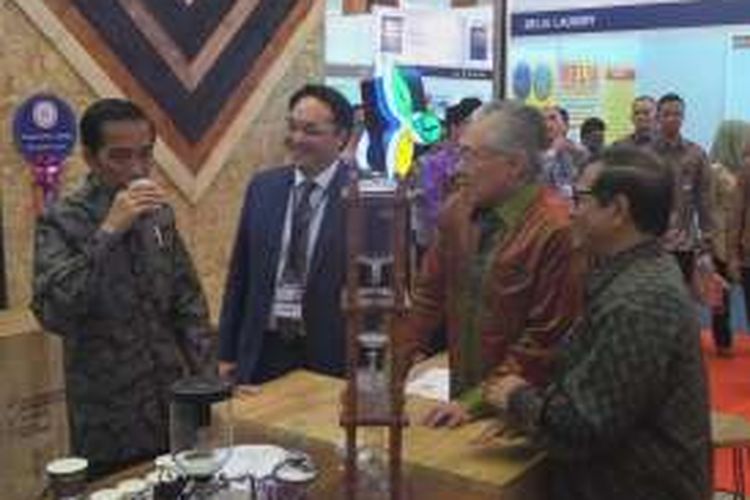 Presiden Joko Widodo mencicipi kopi di waralaba Coffee Toffee, saat pameran di JCC Senayan, Jakarta, Jumat (25/11/2016).