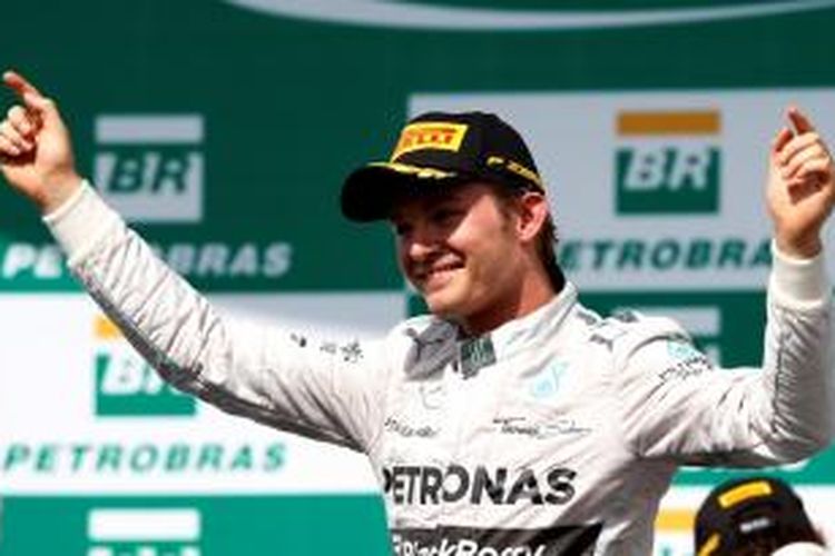 Pebalap Mercedes asal Jerman, Nico Rosberg, merayakan kemenangannya pada balapan GP Brasil di atas podium Sirkuit Interlagos, Minggu (9/11/2014).