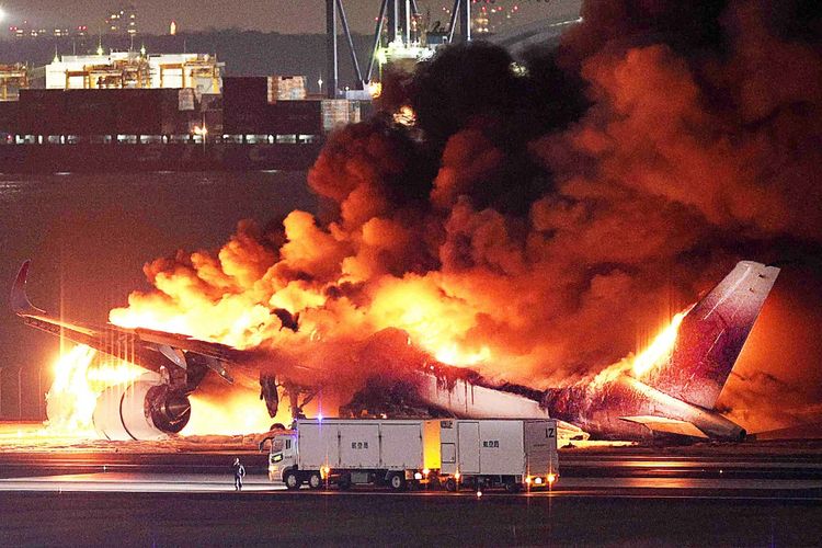 Foto yang disediakan oleh Jiji Press ini menunjukkan sebuah pesawat Japan Airlines terbakar di landasan pacu Bandara Haneda Tokyo pada Selasa (2/1/2024). Pesawat itu terbakar setelah tampaknya bertabrakan dengan pesawat penjaga pantai Jepang.