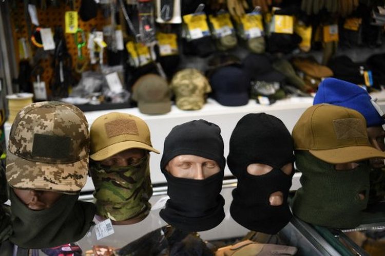 Sebuah gambar menunjukkan balaclavas dipajang di toko perlengkapan militer Milika, di Kyiv, pada 23 Februari 2022.