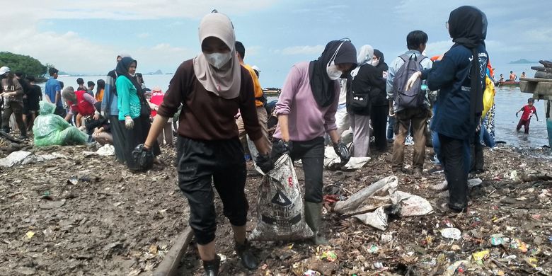Sejumlah masyarakat ikut turun membersihkan Pantai Sukaraja di Bandar Lampung, Senin (10/7/2023).
