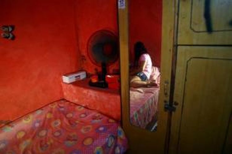 Seorang pekerja seks bersitirahat di kamarnya di kawasan Dolly, Surabaya, 25 Mei 2014. Wali Kota Surabaya Tri Rismaharini telah menetapkan menutup kawasan bordil di Dolly pada 18 Juni 2014.