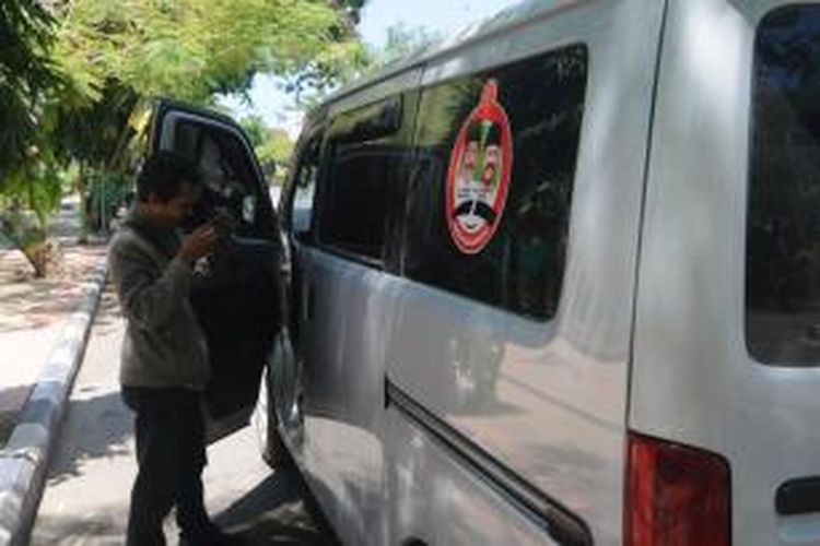 Mobil bergambar pasangan calon gubernur Jawa Timur masih bebas berseliweran di jalan sampai H-1 pemungutan suara.