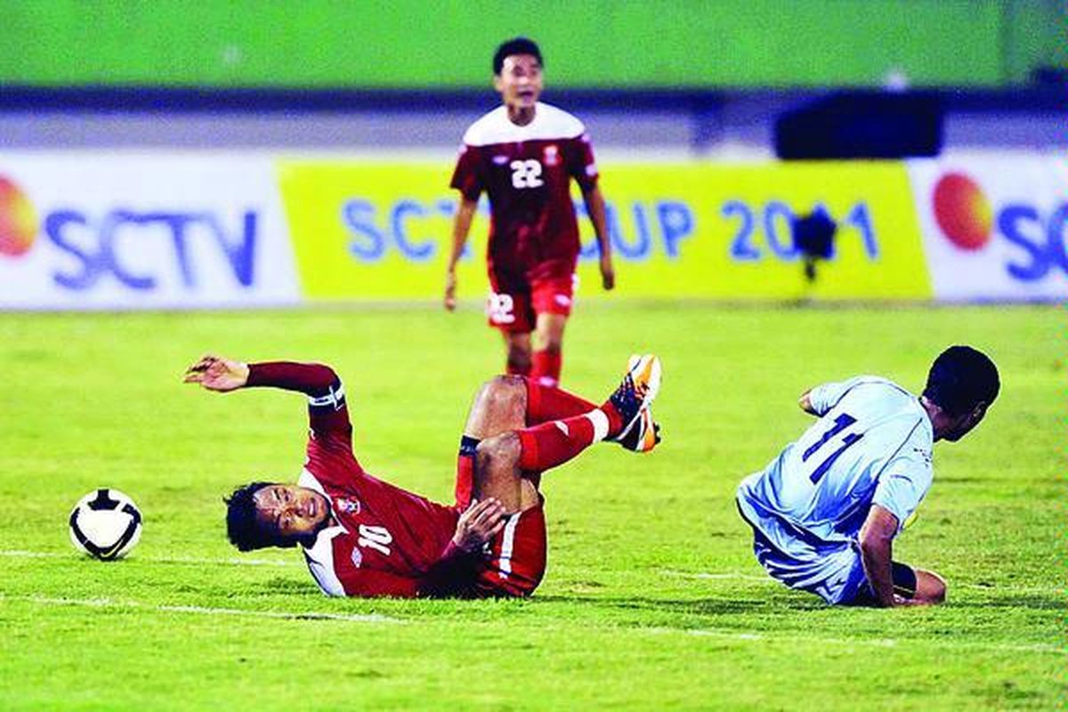 Safee Salli (kiri), kapten tim Pelita Jaya FC, terjatuh setelah berebut bola dengan Satosi, pemain Persela Lamongan, dalam pertandingan kompetisi SCTV Cup 2011 di Stadion Manahan, Solo, Jawa Tengah, Selasa (25/10) malam. Pertandingan berakhir dengan skor 1-1.