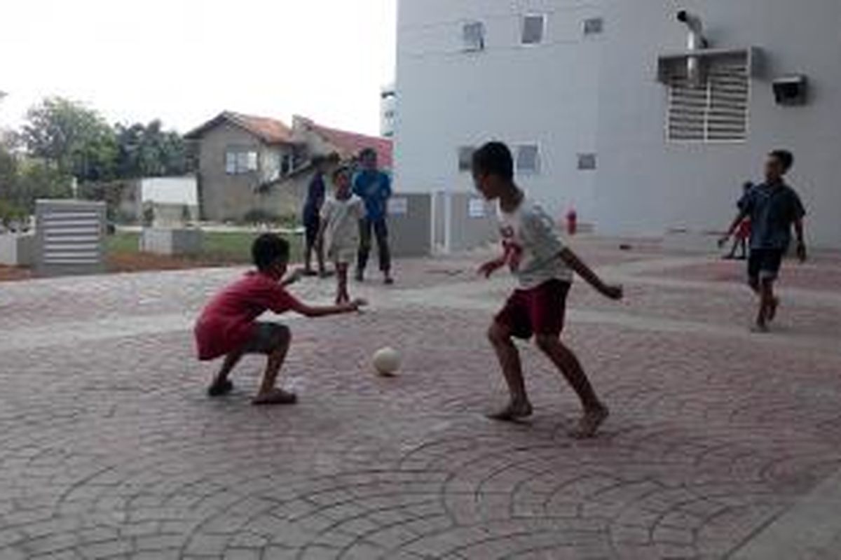 Sejumlah bocah, korban relokasi Kampung Pulo, bermain bola di area kosong di lantai dasar rusunawa Jatinegara Barat, Jakarta Timur, Minggu (23/8/2015).