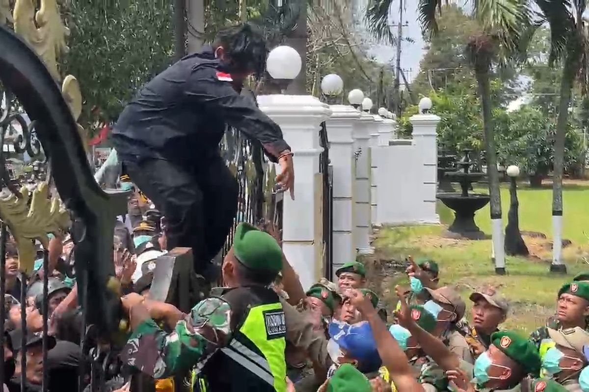 Mahasiswa panjat pagar DPRD Lumajang saat demo tolak UU TNI, Senin (24/3/2025)