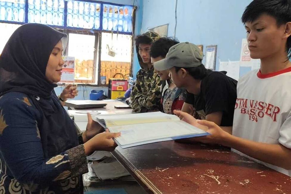 wakil kepala kurikulum SMK Nasional memberikan ijasah kepada salah satu alumni di ruang tata usaha, pada Kamis (1/12/2025) siang