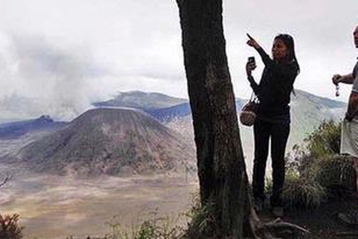 Wisatawan menyaksikan pemandangan Gunung Bromo dari Desa Wonokitri, Kecamatan Tosari, Kabupaten Pasuruan, Jawa Timur, Sabtu (2/4/2011). Aktivitas pariwisata berangsur pulih sejalan dengan dibukanya kembali kawasan Gunung Bromo untuk umum meski tetap diberlakukan jarak aman dalam radius 2 kilometer.