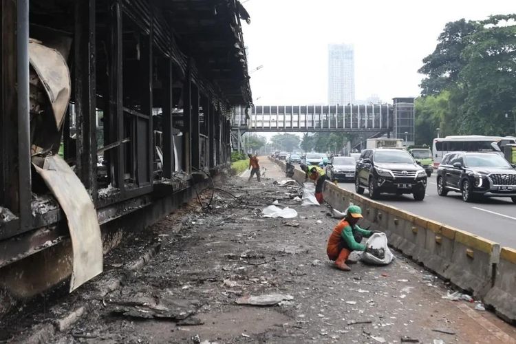 Petugas kebersihan DLH DKI Jakarta membersihkan sampah dan puing-puing akibat aksi pembakaran 
