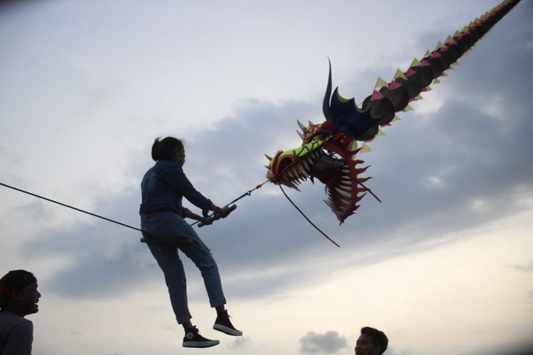 Wisata alternatif di Bantul - Seorang wisatawan sedang menaiki layangan naga raksasa di Kabupaten Bantul, Yogyakarta.