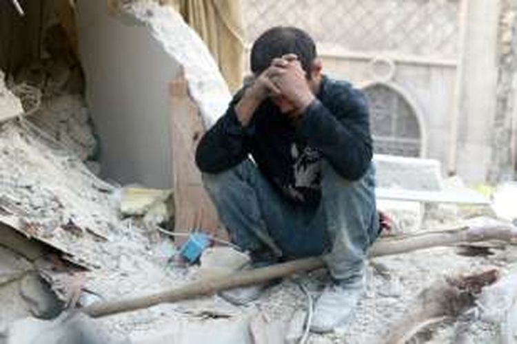 Seorang warga terdiam di antara puing sisa peperangan di Provinsi Aleppo, Suriah.