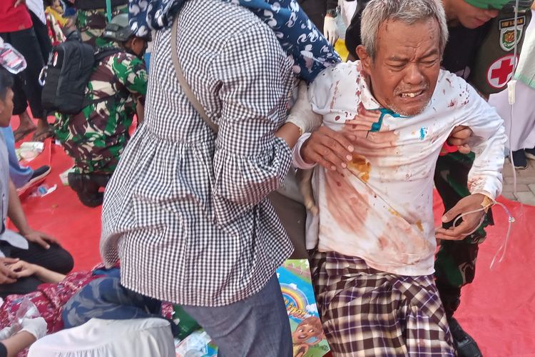 Seorang warga korban gempa Cianjur, Jawa Barat, dibopong untuk menjalani penanganan medis di rumah sakit, Senin (21/11/2022) petang.