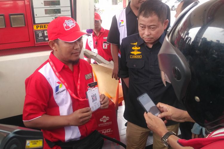 Direktur Pemasaran Retail Pertamina Mas’ud Khamid didampingi Menteri ESDM Ignasius Jonan memperagakan penggunaan T-Cash sebagai alat pembayaran BBM di SPBU wilayah Kertosono, Jawa Timur, Minggu (3/6/2018).