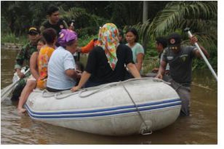 Petugas BPBD dan personel TNI membantu warga Trumon Tengah, Kabupaten Aceh Selatan yang terdampak banjir, warga dievakuasi ke lokasi pengungsian sementara. 