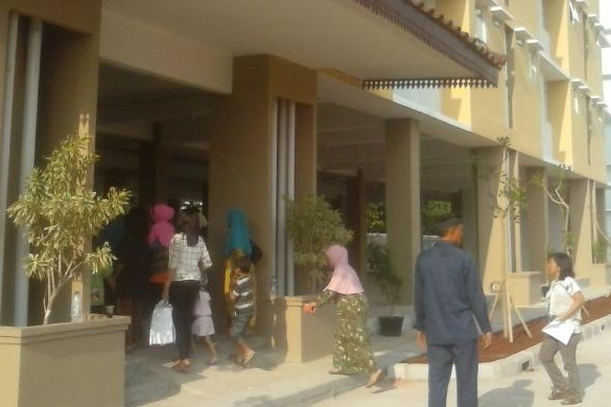 Warga Waduk Pluit berlarian bergegas masuk ke Rusun Muara Baru, Penjaringan, Jakarta Utara, yang akan menjadi tempat tinggal mereka setelah digusur, Jumat (31/10/2014).