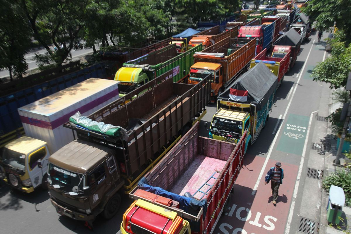 Sejumlah truk berbagai jenis terparkir saat pengemudinya berunjuk rasa di frontage Jalan A Yani, Surabaya, Jawa Timur, Selasa (22/2/2022). Para pengemudi truk itu memprotes aturan terkait over dimension and over loading (ODOL).