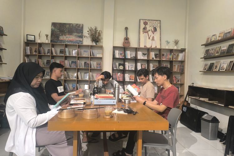 Pengurus Sivitas Kotheka membaca buku dan berdiskusi di Cafe Balada di Kelurahan Lawangan Daya, Pamekasan, Minggu (10/8/2025) malam.