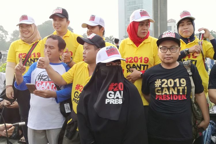 Sejumlah warga tampak memakai baju dan kaos #2019GantiPresiden di Bundaran HI, Jakarta, Minggu (29/4/2018)