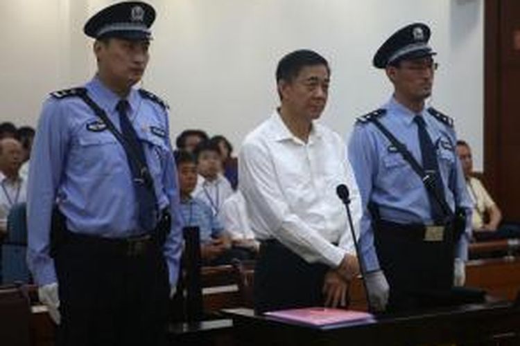 Dalam foto yang dirilis pengadilan kota Jinan, China ini terlihat politisi karismatis Bo Xilai menghadiri sidang dengan dikawal ketat dua orang polisi.