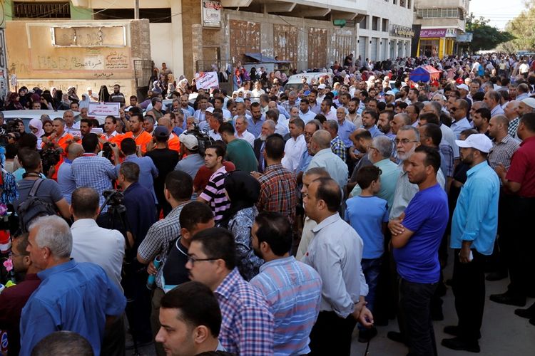Ratusan staf dan karyawan UNRWA saat melakukan aksi pemogokan di depan kantor UNRWA di Gaza, menuntut pembatalan pemangkasan pekerja.