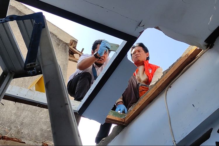 Tim Inafis satreskrim Polres Trenggalek.lalukan olah TKP di lokasi balon udara ber petasan yang jatuh timpa rumah warga kelurahan Surodakan Trenggalek, Jawa Timur, Senin (7/4/2024).