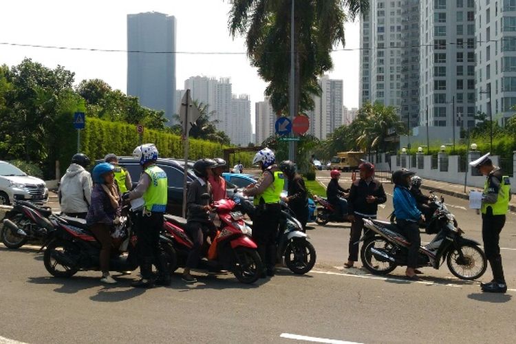 Polisi melakukan penindakan terhadap pengendara sepeda motor yang nekat melintas di JLNT Casablanca, Selasa (25/7/2017).