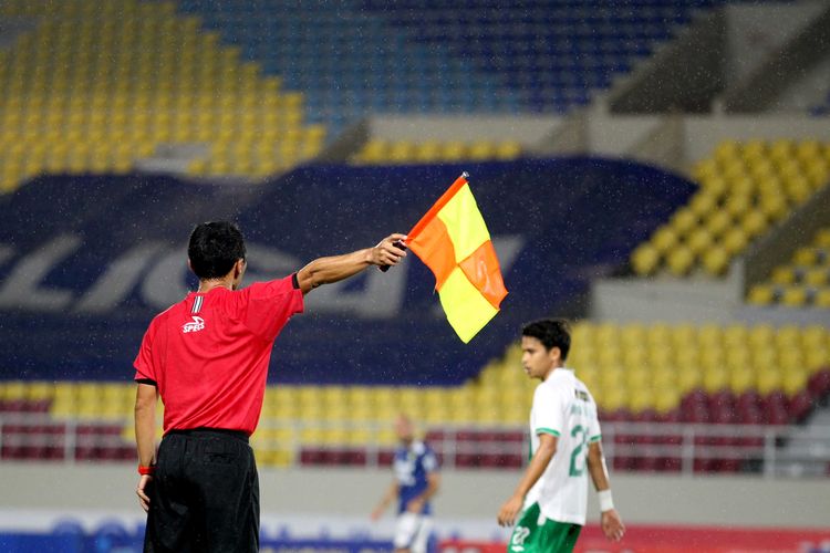Hakim garis Liga 1 2021-2022 mengangkat bendera.
