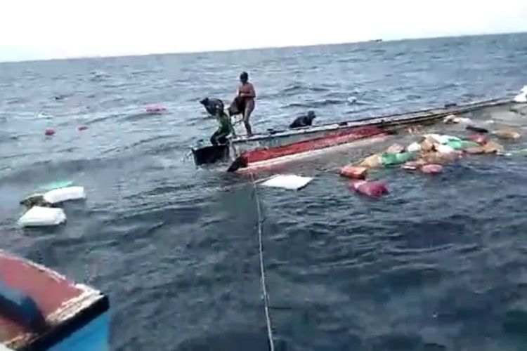 Tiga orang berada di atas kapal yang tampak tenggelam dengan sejumlah barang-barang dalam kapal berserakan di perairan Kepulauan Seribu, Jumat (23/12/2022).