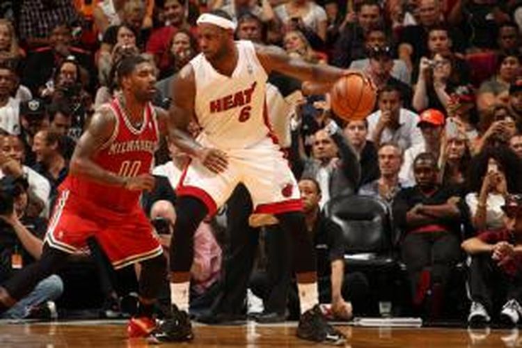 Pebasket Miami Heat, LeBron James (6) menguasai bola saat mencoba melewati pemain Milwaukee Bucks, O.J. Mayo (00), pada pertandingan lanjutan di American Airlines Arena, Miami, Selasa (12/11/2013).