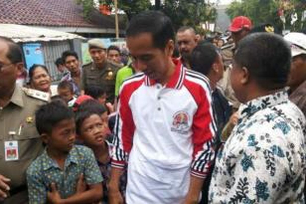 Gubernur DKI Jakarta Joko Widodo disambut anak kecil saat menyambangi Kelurahan Sungai Bambu, Kecamatan Tanjung Priok, Jakarta Utara, Selasa (17/12/2013). Kunjungannya siang ini dalam rangka Deklarasi Kota Layak Anak Wilayah DKI Jakarta. 