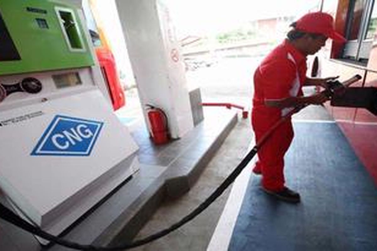 Petugas mengisi bahan bakar gas (BBG) jenis gas alam terkompresi (compresed natural gas/CNG) ke bus Transjakarta