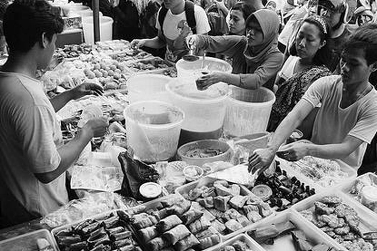 Pedagang melayani warga yang membeli barang dagangan mereka di pasar tumpah makanan berbuka puasa di Jalan Bendungan Hilir, Sabtu (21/7). Selama Ramadhan, pasar tiban ini selalu dipadati warga, terutama saat menjelang berbuka puasa.