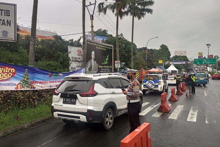 Sejumlah petugas kepolisian melakukan rekayasa lalu lintas di jalur Puncak Bogor, Jawa Barat, Jumat (30/12/2022).