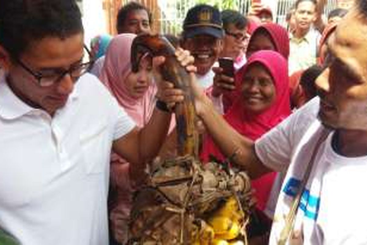 Calon wakil gubernur DKI Jakarta Sandiaga Uno menerima buah-buahan usai berkampanye di Kramat Jati, Pasar Rebo, Jakarta Timur, Kamis (8/12/2016).