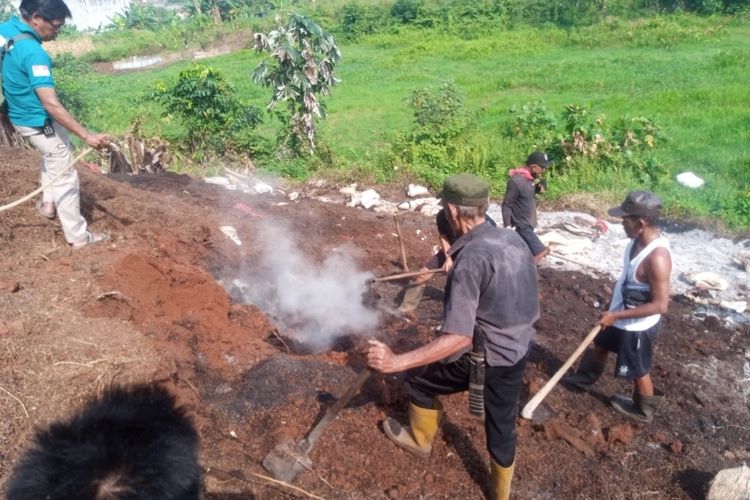 Warga Kademangan bergotong royong mencari titik api yang masih membakar tumpukan ampas cabai di lahan kosong di RT 002 RW 002, Kademangan, Setu, Tangerang Selatan pada Jumat (18/8/2023).