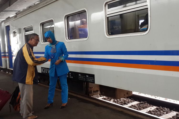 Seorang pramugari Kereta Api (KA) di Stasiun Kota Malang saat melayani penumpang, Kamis (14/12/2017)